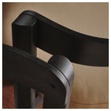 Nahaufnahme eines schlanken, schwarzen Holzstuhls mit glatten Kurven, der hochwertige Handwerkskunst zeigt. Das dunkle, polierte Finish unterstreicht das elegante Design.