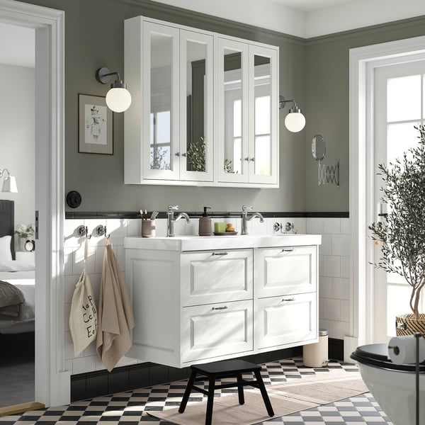 Moderner Waschtisch mit Doppelwaschbecken in Weiß mit Spiegelschrank, schwarz-weißem Schachbrettboden, grüner Wand und hängenden Handtüchern.