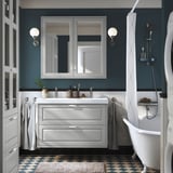 Modernes Badezimmer mit grauem TÄNNFORSEN-Waschtisch, Doppelwaschbecken und dunklen blaugrünen Wänden.