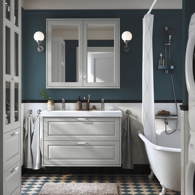 Modernes Badezimmer mit grauem TÄNNFORSEN-Waschtisch, Doppelwaschbecken und dunklen blaugrünen Wänden.