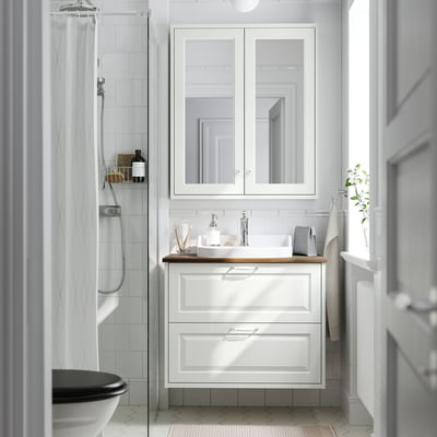 Weißer Waschtisch TÄNNFORSEN mit Waschbecken, Holztheke, Spiegelschrank, helles Badezimmer.