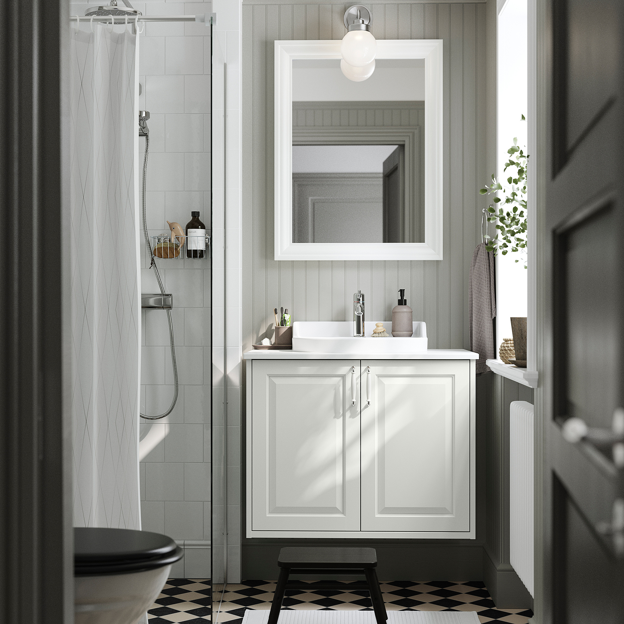 Ein weißer TÄNNFORSEN Badezimmerschrank, schmal, mit Waschbecken, Spiegel und schwarz-weißem Boden.