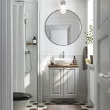 Modernes Badezimmer mit grauem TÄNNFORSEN-Waschtisch, weißem Waschbecken, Spiegel und Glasduschtür.
