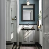 Modernes Badezimmer mit TÄNNFORSEN-Waschtisch, schwarzer Theke, Waschbecken, Spiegel und Glasdusche.
