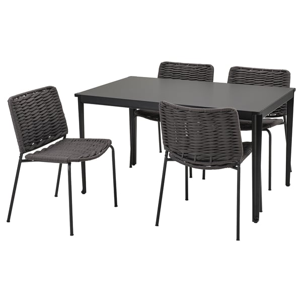Schwarzer quadratischer Outdoor-Tisch mit vier passenden Korbstühlen. Modernes, minimalistisches Design mit Metallbeinen.
