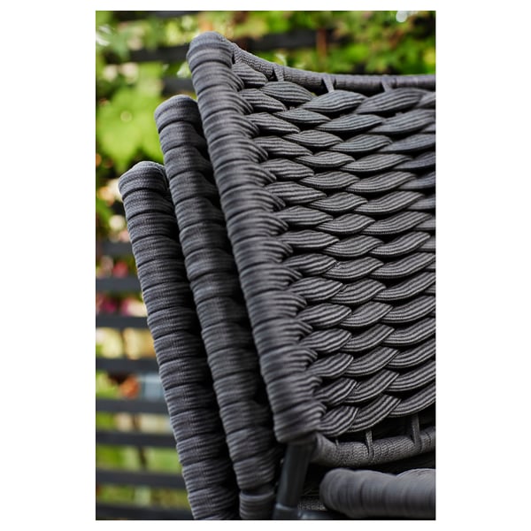 Dunkelgrauer Outdoor-Stuhl aus nächster Nähe mit gewebter Seilstruktur. Metallrahmen darunter.