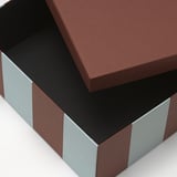 Geschlossener brauner Karton mit silbernen Akzenten, hochwertig aussehend und robust.