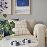 Blau-weißer TRÄDSTAM Teelichthalter, Schwimmring-Design, auf Tisch in der Nähe des Sofas.