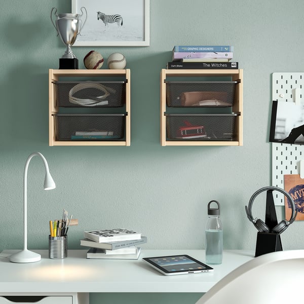 TROFAST Regale mit dunklen Boxen bieten Platz für Sportartikel und Bücher. Der Schreibtisch darunter hat eine Lampe, Bücher, Stifte, Tablet, Wasserflasche an einer hellblauen Wand.