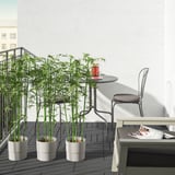 Kleine, weiße, quadratische UTLÄNGAN-Balkonterrasse, die sich gut unter einen niedrigen Metalltisch und Stühle einfügt.