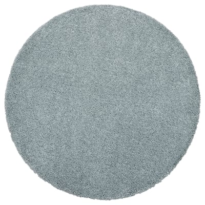 Runder, hellblauer, zotteliger Teppich. Hergestellt aus Polypropylen, weiche und weiche Textur.