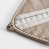 Gefaltetes beiges Kissen mit weißen Mittelnähten, die hochwertigen Stoff und Handwerkskunst präsentieren.