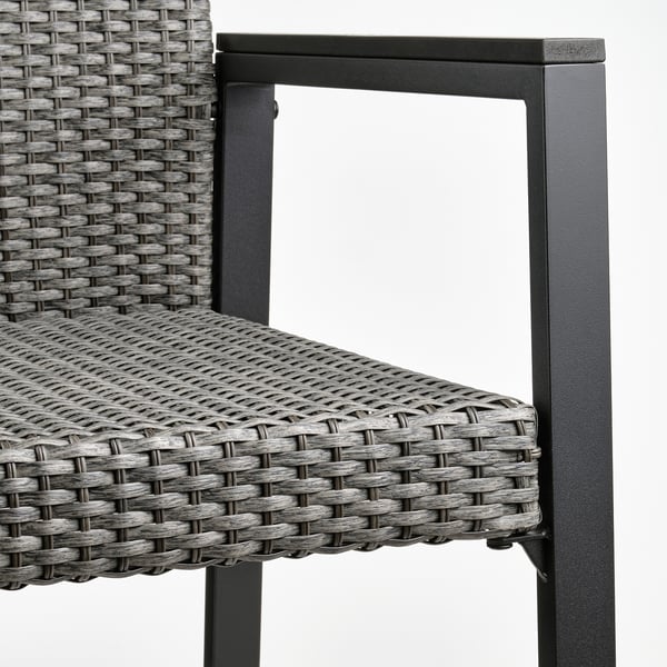 Moderner Outdoor-Stuhl, Nahaufnahme. Robustes schwarzes Korbgeflecht auf robustem Metallrahmen, gebaut für Komfort und Langlebigkeit.