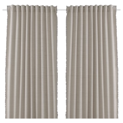 Zwei beige Vorhänge hängen nebeneinander. Hergestellt aus recycelten Materialien mit Fransendetails. Einfach, leicht und plissiert.