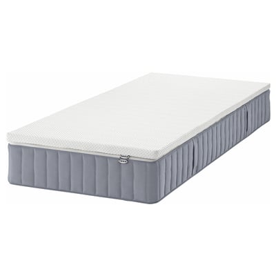 Eine IKEA VALEVÅG Taschenfederkernmatratze in Weiß und Grau mit einer Memory-Foam-Oberseite, die für Seitenschläfer oder schwerere Rückenschläfer konzipiert ist.