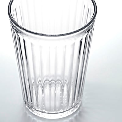 Klarer, kannelierter Glasbecher aufrecht abgebildet, leer. Einfaches Design, langlebig, transparent und elegant.