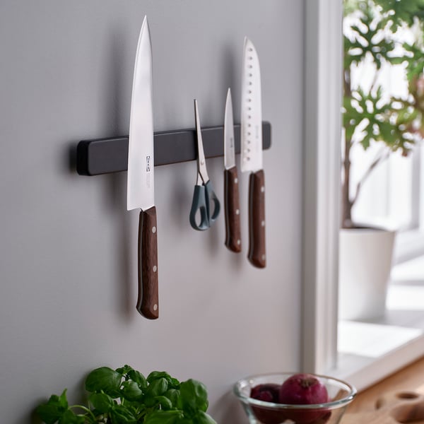 Eine moderne Küchenwandhalterung nimmt Messer und Scheren auf; Praktisch für die Zubereitung in der Nähe eines Fensters mit frischen Kräutern und Früchten darunter.