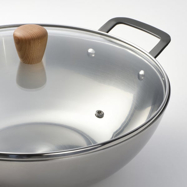 Wok aus Edelstahl mit Deckel und Holzgriffen.
