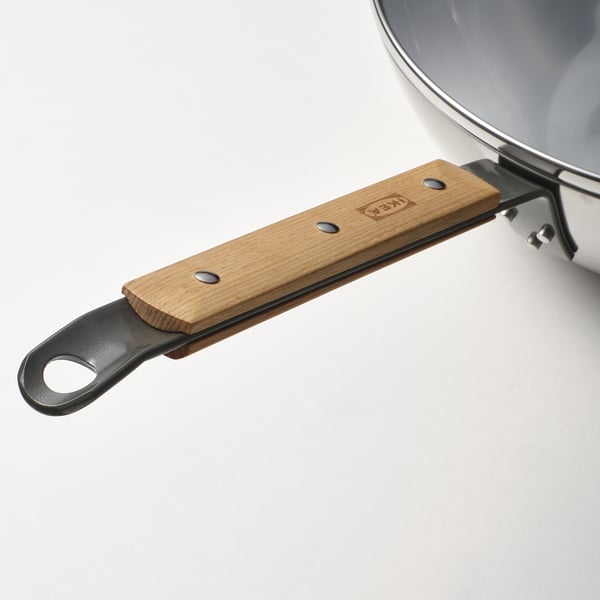 Nahaufnahme eines robusten Wok-Griffs mit Holzgriff und Metallschlaufe, der mit Schrauben sicher befestigt ist und ein robustes Design auf einem sauberen weißen Hintergrund zeigt.