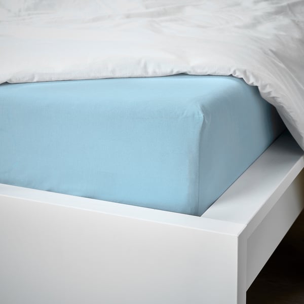 Ein ordentlich gemachtes Bett mit einem hellblauen Spannbettlaken und einem weißen Kissen auf einem weißen Rahmen.