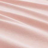 Nahaufnahme aus weichem, rosa-rotem Baumwollstoff, glatte Textur, leicht zerknitterte Falten.