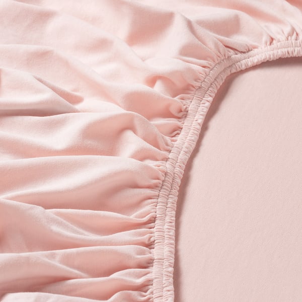 Nahaufnahme aus hellrosa Baumwolljersey mit weicher Textur und elastischen Kanten.