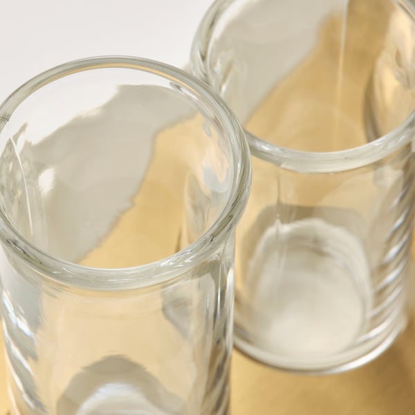Vasen aus klarem Glas, die mit Präzision handgefertigt sind, auf beigem Stoff sitzen und Qualität und Eleganz zeigen.