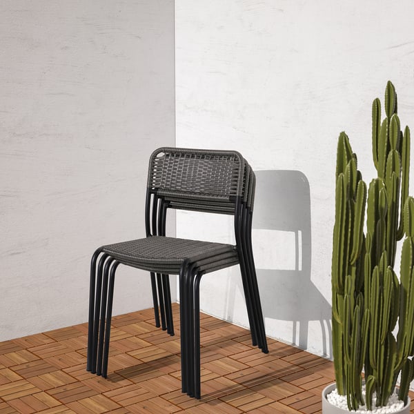 Stapelbarer Outdoor-Stuhl mit Kunststoffrattan, langlebig und witterungsbeständig. Dargestellt vor einer hellen Wand und neben einem großen Kaktus.