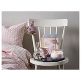 Gemütliches Schlafzimmer mit Stuhl, Tisch und Blumen.