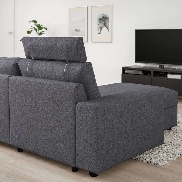 Das VIMLE Sofa in Dunkelgrau mit verstellbarer Kopfstütze und Chaiselongue in einem Wohnzimmer mit TV und Teppich.