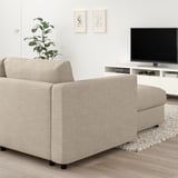 Modernes hellbeige Sofa VIMLE im Wohnzimmer. Schlankes Design mit Liege, großem Fernseher und Pflanze.
