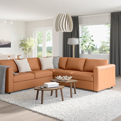 Modernes Wohnzimmer mit Sofa aus hellbraunem VIMLE-Leder, Beistelltischen, Teppich und Dekor.