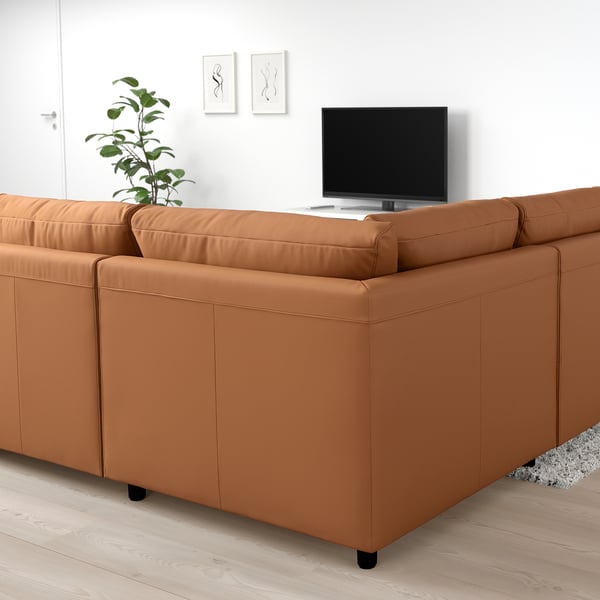 Modernes Wohnzimmer mit orange-braunem IKEA VIMLE Couchsofa, Flachbildfernseher und Pflanze.
