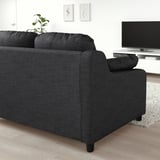Modernes Wohnzimmer mit großem schwarzen VINLIDEN-Sofa, TV und Dekor.