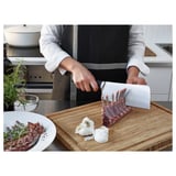Chefkoch schneidet Lammkarree in der Küche.
