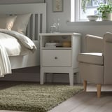 Schlafzimmer: weißes Bett, Teppich VOLLERSLEV, Nachttisch, Sessel, Fenster.