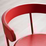 Leuchtend rotes Stuhldetail; glatter, geschwungener Rücken, robuste Beine; Hochwertiges Design.