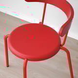 Roter moderner Stuhl auf Holzboden. Runder Sitz, geschwungene Rückenlehne, Metallbeine. Lebendiges, stilvolles Design.
