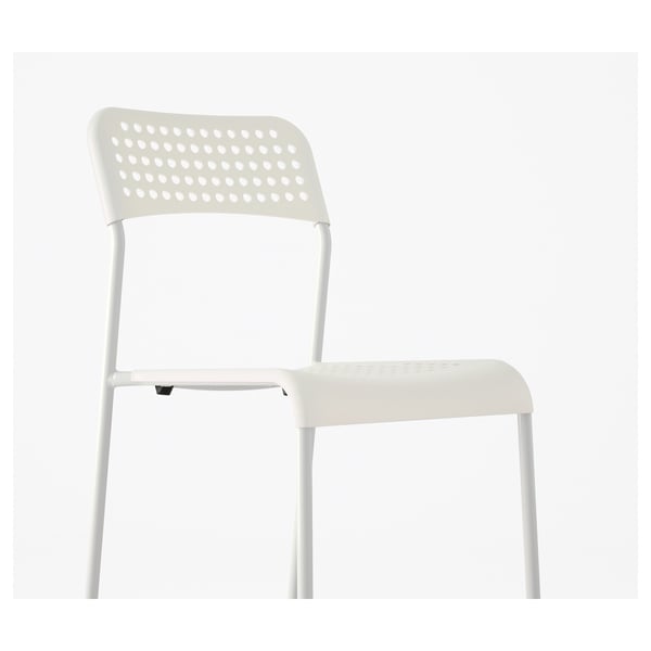 White plastic chair with perforated backrest, sturdy legs, stackable design. Ideal for space-saving and extra seating.