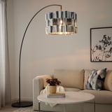 ÄLVSTARR floor lamp illuminates living room, highlighting sofa, table, plant, and wall art.