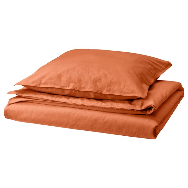 An ÄNGSLILJA orange bedding set, neatly folded. It includes a duvet cover and pillowcases made of soft, pre-washed cotton in a warm, earthy shade.