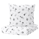 A white square pillow and folded sheet from the AFTONSPARV collection, featuring a black space theme with rockets, planets, and stars.