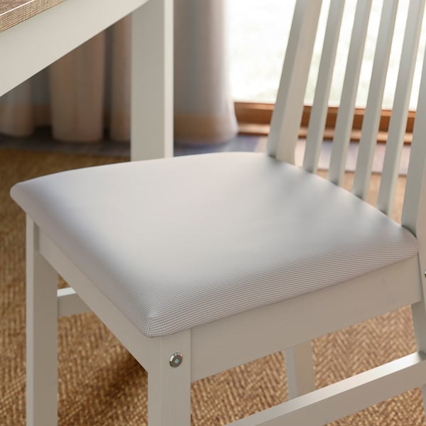 Close-up of a modern chair with soft cushioned seat, sleek wood frame, and stylish design.