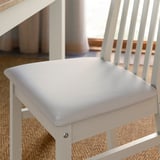Close-up of a modern chair with soft cushioned seat, sleek wood frame, and stylish design.