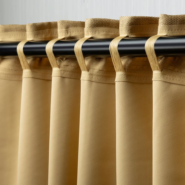Curtains hanging with hooks and rod, blocking light, offering privacy.