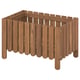 A wooden planter named ASKHOLMEN, made of acacia, with a natural brown stain. It has peg slats and stands on four legs.