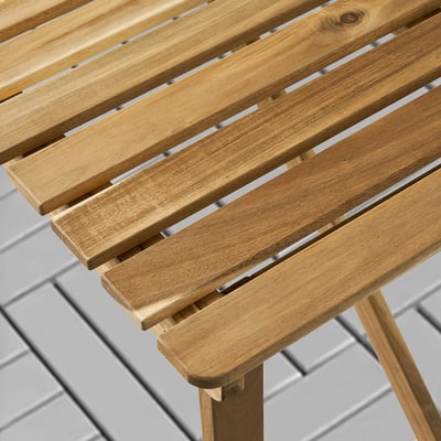 Wooden outdoor table, well-constructed with smooth, light brown slats, showing quality craftsmanship and durable design.