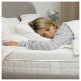 Woman sleeping peacefully on white ÅVABERG mattress.