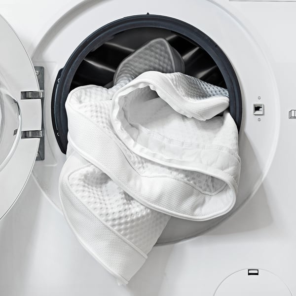 Washed mattress topper in dryer, showing easy-care feature.