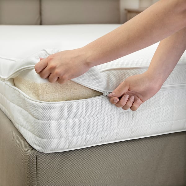 Person zipping up a white mattress cover, highlighting the removable feature for easy cleaning.